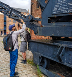 Photo of two participants taking photos of an old crane at Gloucester Docks