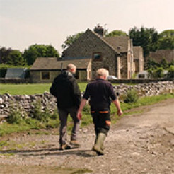 Photo of two farmers walking their farm
