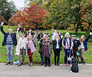 Group photo of about 20 participants looking happy and waving arms in the air 