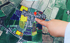 Image of a hand pointing to map of rural land on a computer screen