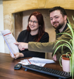 Emma Eccleston and Joshua Lee look at a sheaf of utility bills together