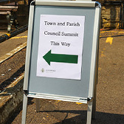 Photo of a sign board pointing the way to the Town and Parish Council Summit